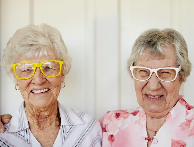 Kaksi iloista silmälasipäistä eläkeikäistä