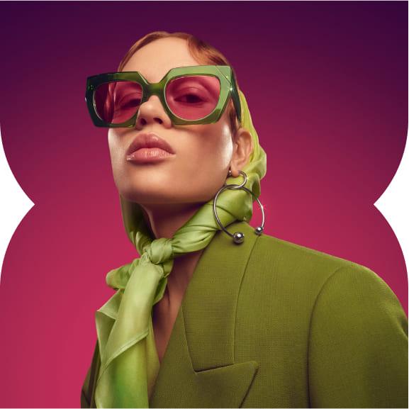 Kvinna med gröna kläder och solglasögon