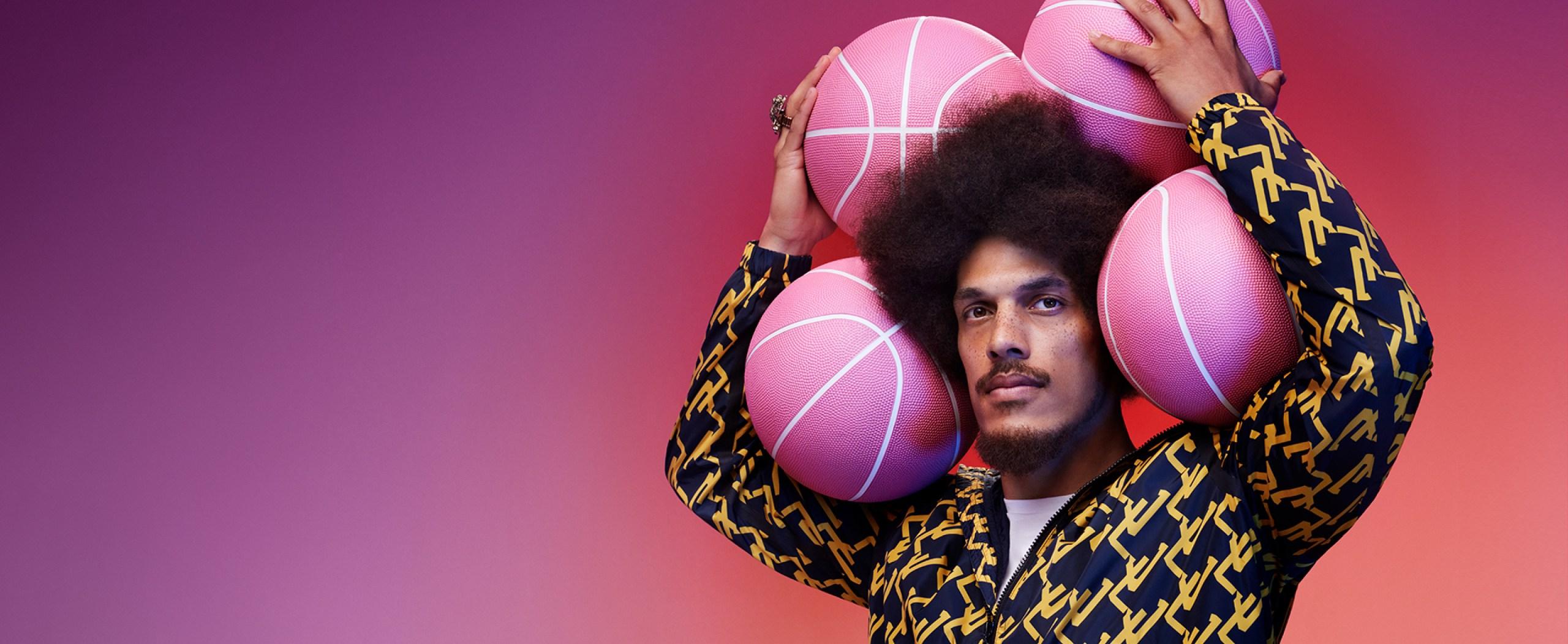 Man holding four pink basketballs